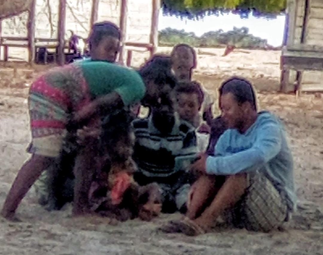 Andry the interpretor sitting with kids looking at phone