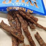 Dried salmon strips spilling from blue packaging.