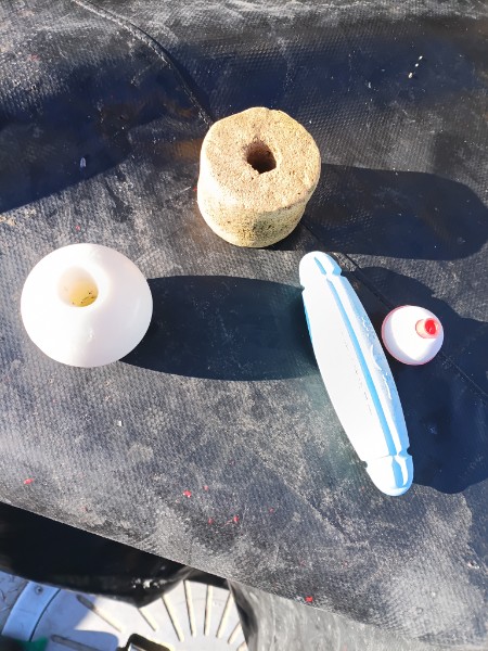 Fishing floats and bobbers on black mesh surface