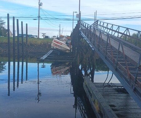 Fishing boat docked near metal pier ramp